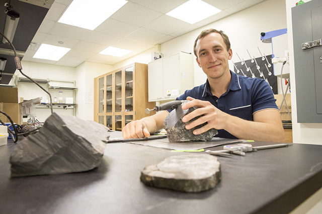Erik Gulbranson, paleoecólogo y profesor asistente visitante en UWM, estudia algunos de los árboles fosilizados que trajo de la Antártida. Gulbranson regresará allí para realizar más investigaciones este año