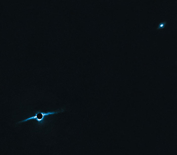 La estrella HD 106906 y su disco de residuos en la parte inferior izquierda, con el planeta HD 106906b arriba a la derecha.