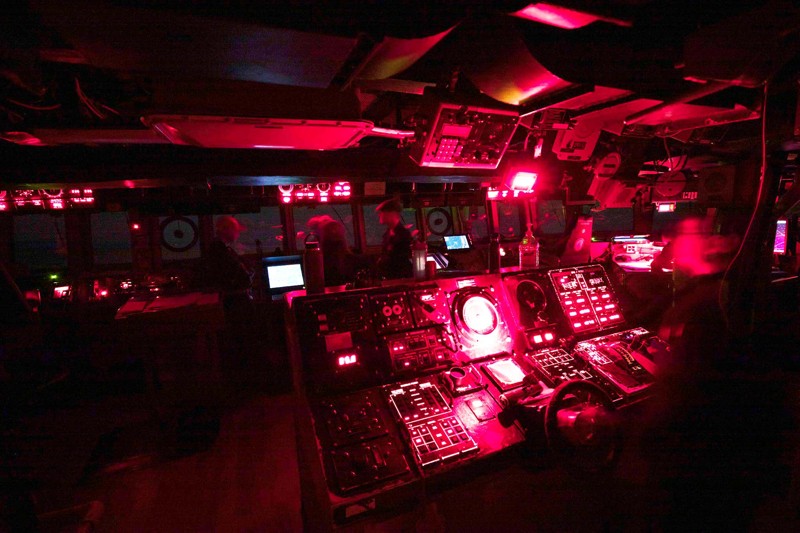 El puente iluminado en rojo de un destructor de la clase Arleigh Burke por la noche