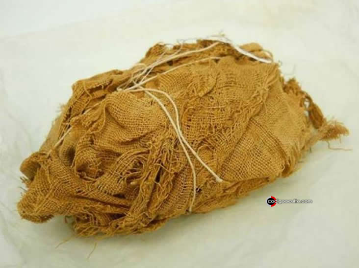 Paquete de lino todavía envuelto (sostenido por una cuerda moderna) encontrado en una tumba excavada en la roca en Qau el-Kebir, hacia 1922-24