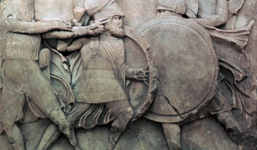 Relieve en piedra de guerreros espartanos en batalla