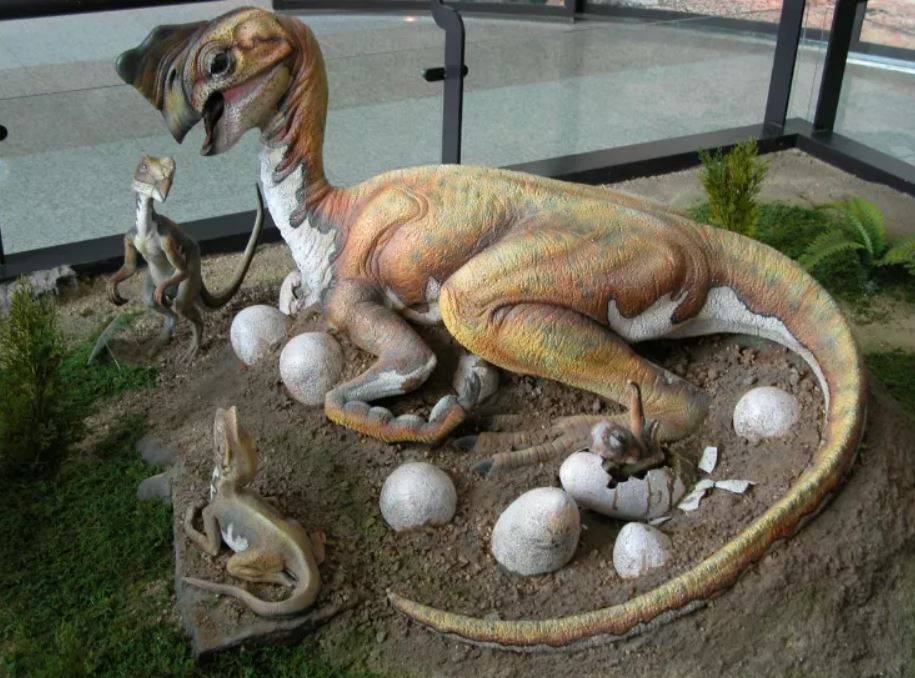 Un dinosaurio oviraptórido con sus huevos y crías