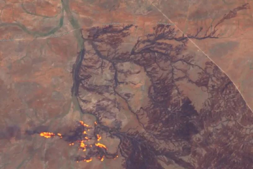 Incendio en zonas áridas que se desplaza a lo largo de arroyos secos y líneas de drenaje