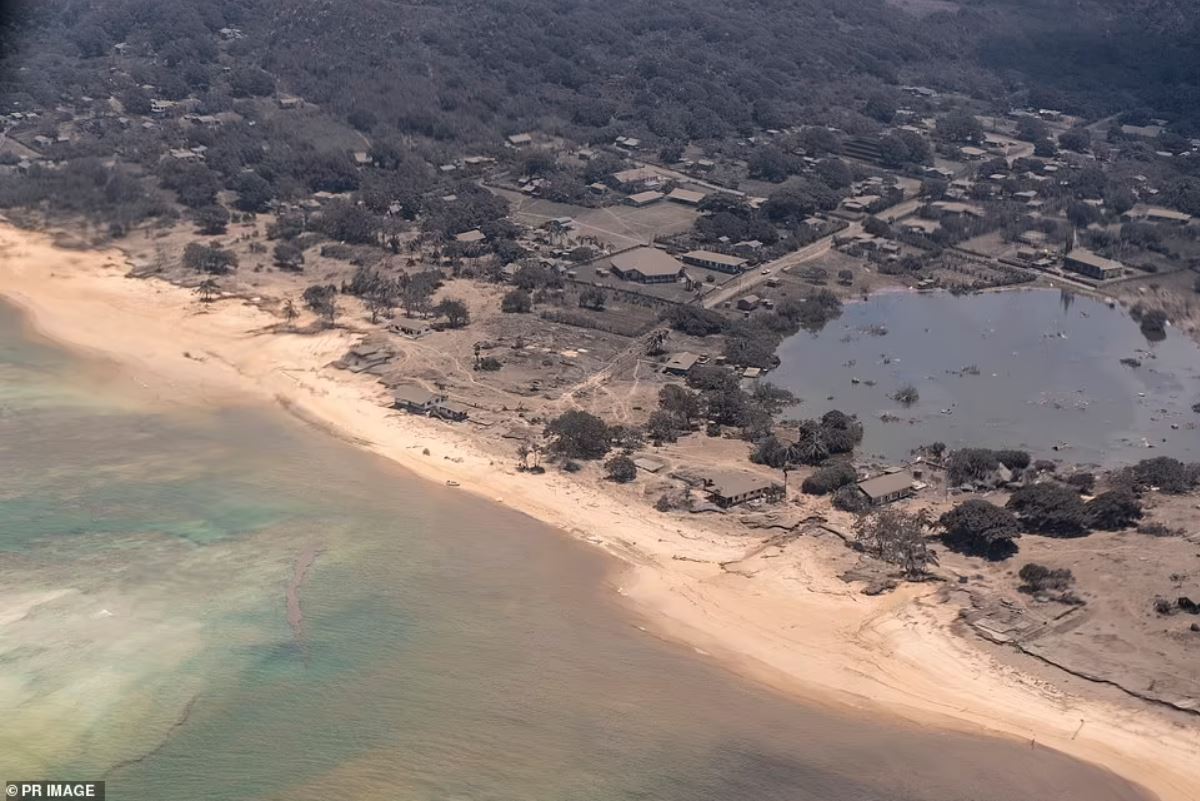 Los edificios se ven cubiertos de ceniza con daños por agua visibles a lo largo de la costa de una isla de Tonga en esta imagen tomada desde un avión de reconocimiento de la fuerza aérea de Nueva Zelanda
