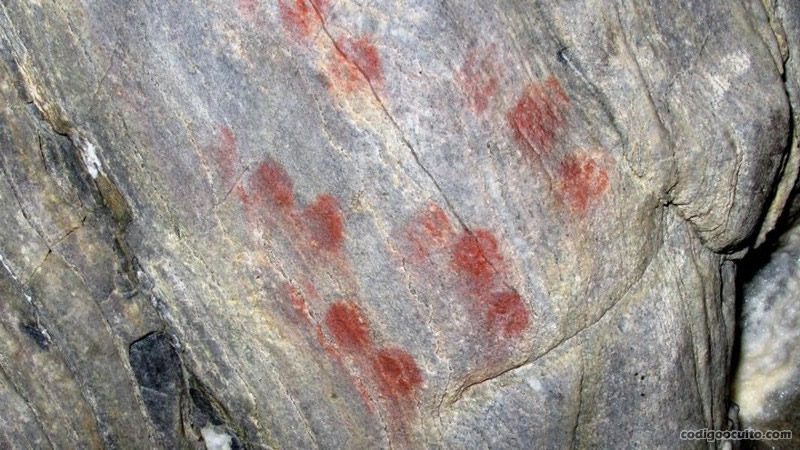 Cueva de ardales: signos de puntuación en color rojo hechos con la yema de los dedos