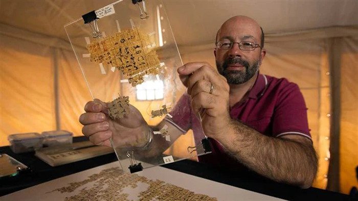 El arqueólogo Pierre Tallet sostiene un antiguo papiro