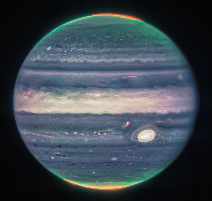 Una imagen compuesta de júpiter tomada por la nircam de webb; el resplandor naranja alrededor de los polos es la aurora