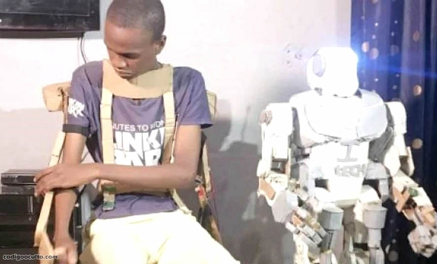 El joven nigeriano, Isah Auwal-Barde, junto al robot que construyó usando chatarra y otros desechos electrónicos