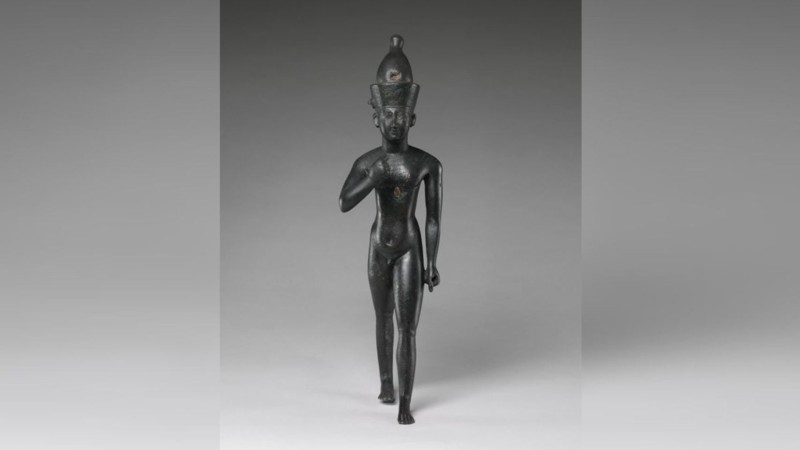 Una estatuilla del dios niño Harpócrates, que se muestra aquí desnudo con un dedo roto.  Esta imagen de metal es probablemente del delta oriental, Tanis, Egipto, no de Berenike, como el templo descrito en este artículo.