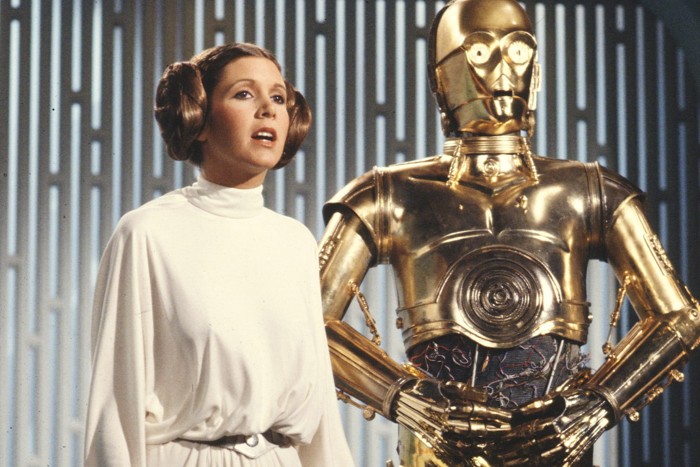 La inolvidable Carrie Fisher junto al popular C3PO, recordado androide del universo Star Wars, inspirado en el robot de Metrópolis, que como sabemos fue influenciado por fuentes griegas