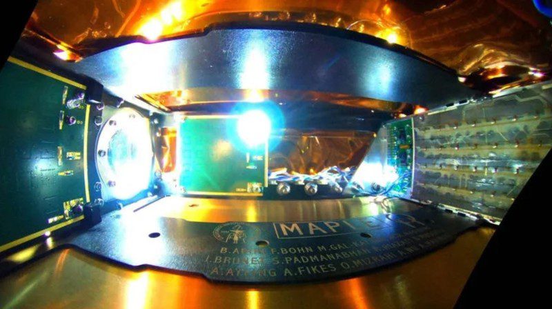 El interior de Microwave Array for Power-transfer Low-orbit Experiment (MAPLE) con base en el espacio que emite energía recolectada a través del espacio vacío utilizando una matriz de transmisores (derecha) a dos receptores (derecha) para iluminar un LED.