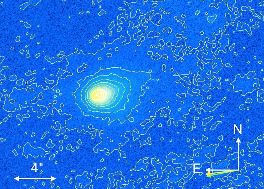 Imagen del telescopio espacial Hubble de 3I/ATLAS, que muestra un brillo difuso y asimétrico que precede al objeto. Las flechas amarillas y verdes marcan, respectivamente, el vector de velocidad heliocéntrica negativa proyectada y la dirección antisolar proyectada.