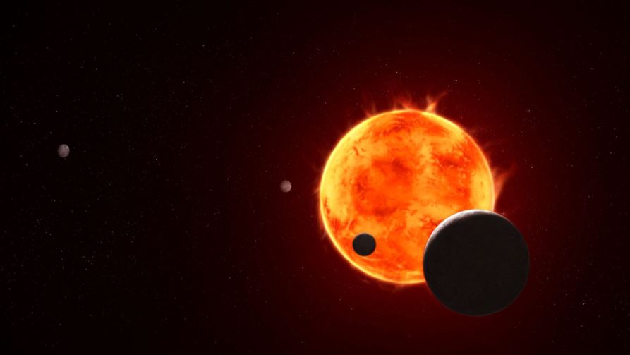 El exoplaneta TRAPPIST-1 e, del tamaño de la Tierra, representado en la parte inferior derecha, se perfila al pasar frente a su brillante estrella anfitriona en esta representación artística del sistema TRAPPIST-1. Los científicos denominan a este fenómeno «tránsito», durante el cual se pueden recopilar datos valiosos cuando el exoplaneta pasa entre la estrella y el telescopio y la luz estelar ilumina la atmósfera, si la hay.